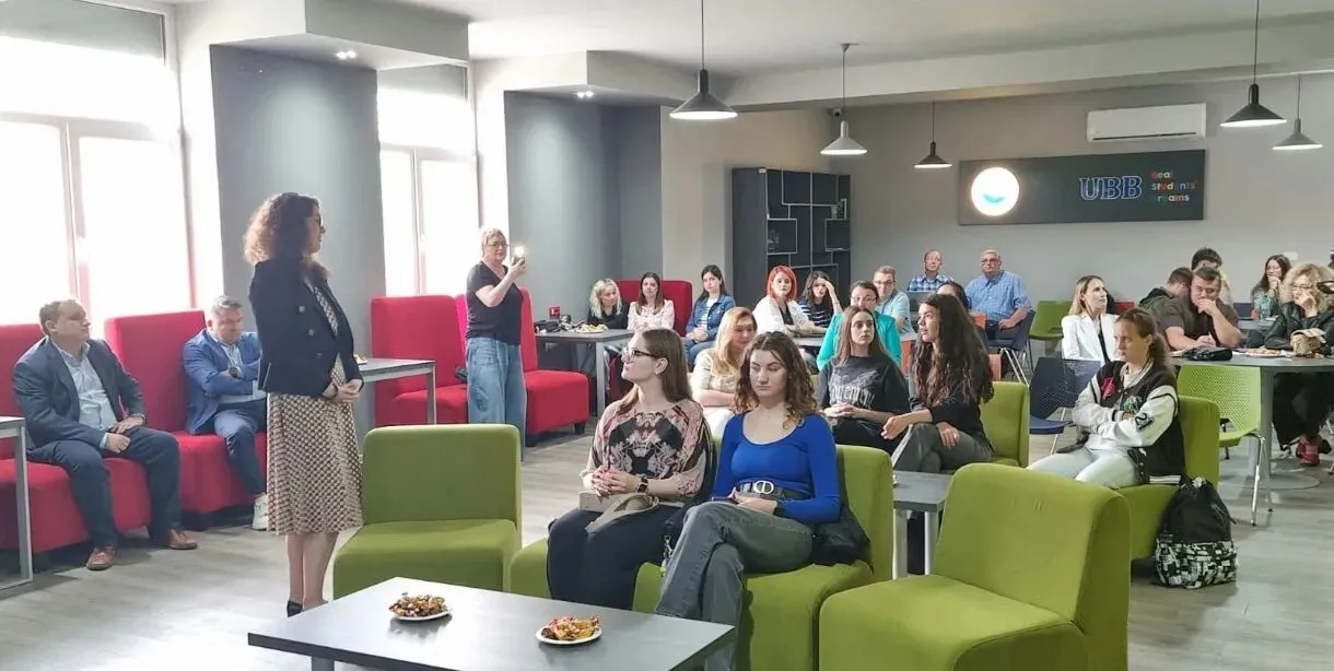 Workshop participants seated in a meeting space, listening to Raluca Spataru presenting