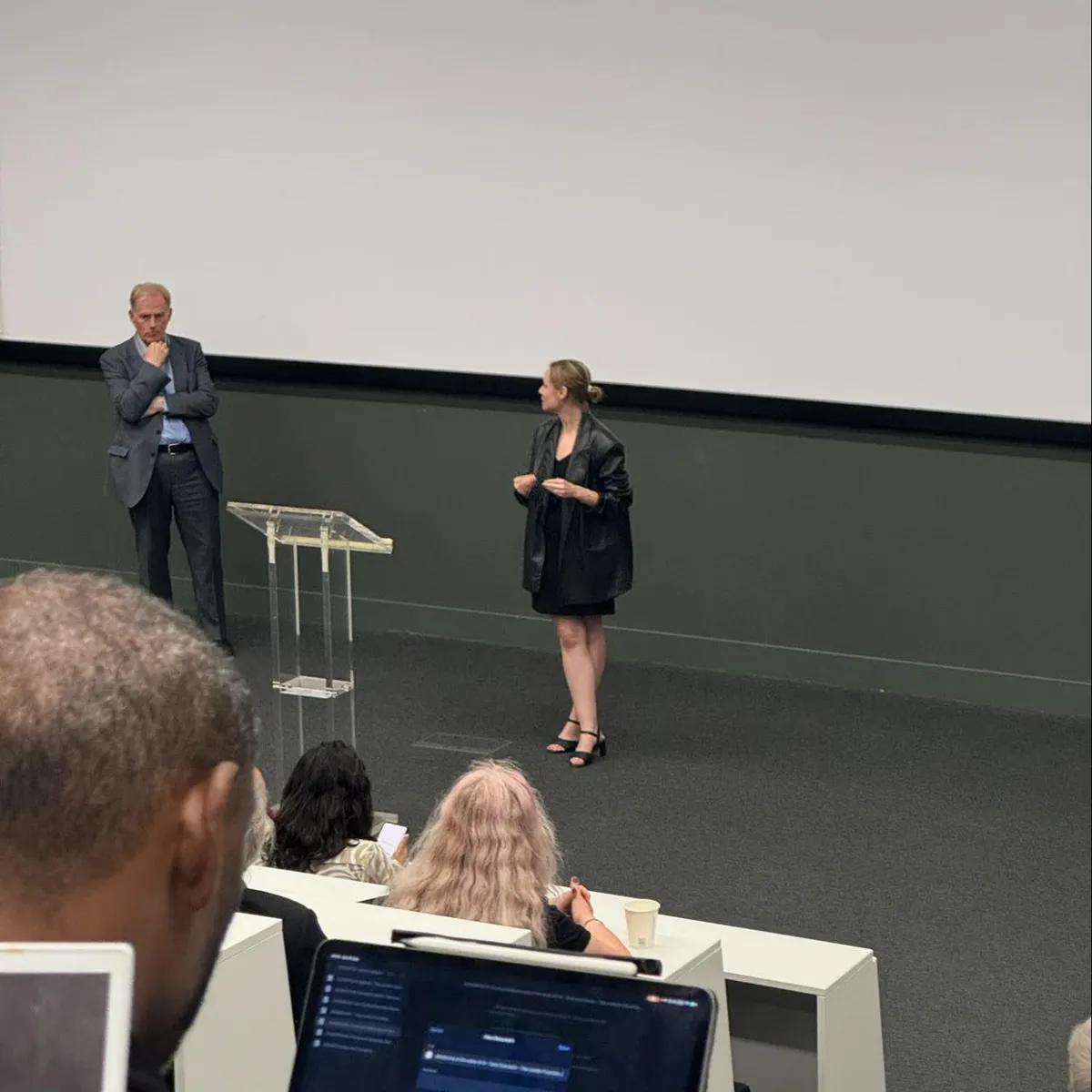 Karolina Gruzel and another speaker on stage at a fireside chat, watched by an audience